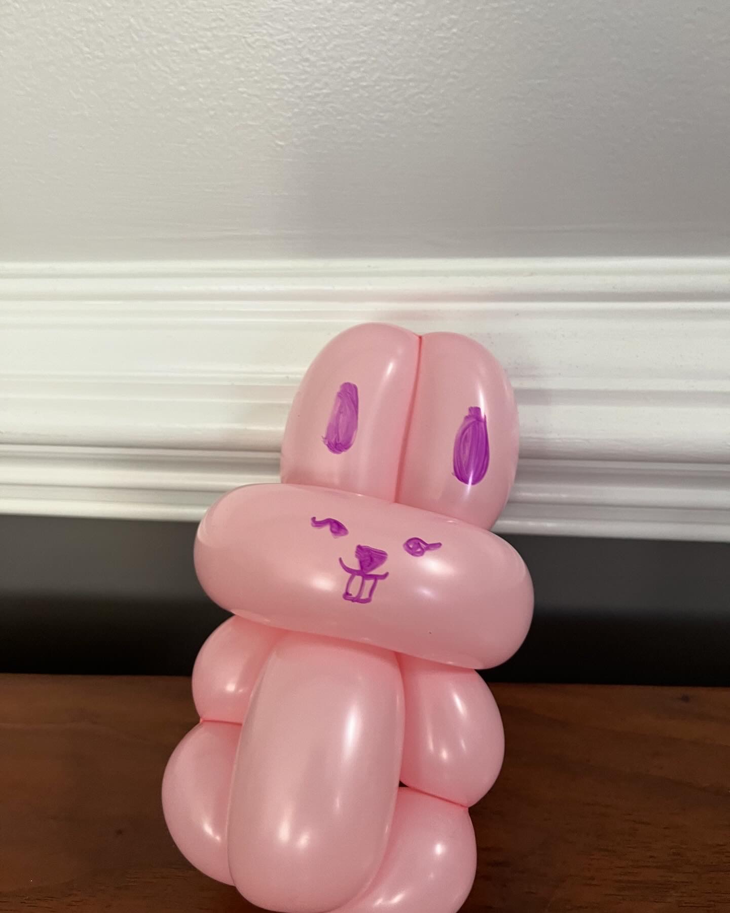 Pink balloon bunny with a hand-drawn face